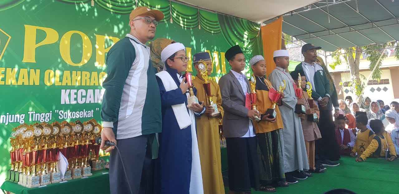 Panitia menyerahkan hadiah bagi para juara dalam Porseni MI Tahun 2023 se-Kecamatan Bungah. Foto: Atiq Mujahid/NUGres 