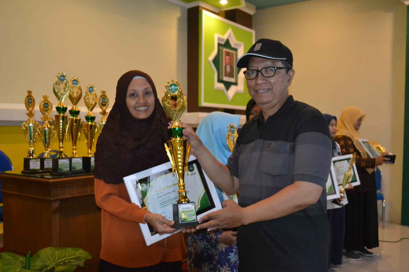 Ketua Pimpinan Anak Cabang Pesatuan Guru Nahdlatul Ulama Gresik, saat menyerahkan trofi dan sertifikat kepada para Juara Lomba Baca Puisi. Foto: dok PAC Pergunu Gresik/NUGres