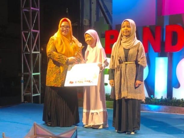 Raeesa, Juara 1 lomba menggambar Bandar Grissee GPA PWI Gresik saat menerima tropi dan hadiah yang diserahkan oleh Wakil Bupati Gresik Hj Aminatun Habibah. Foto: dok MI Al Hidayah Banjarsari Cerme/NUGres