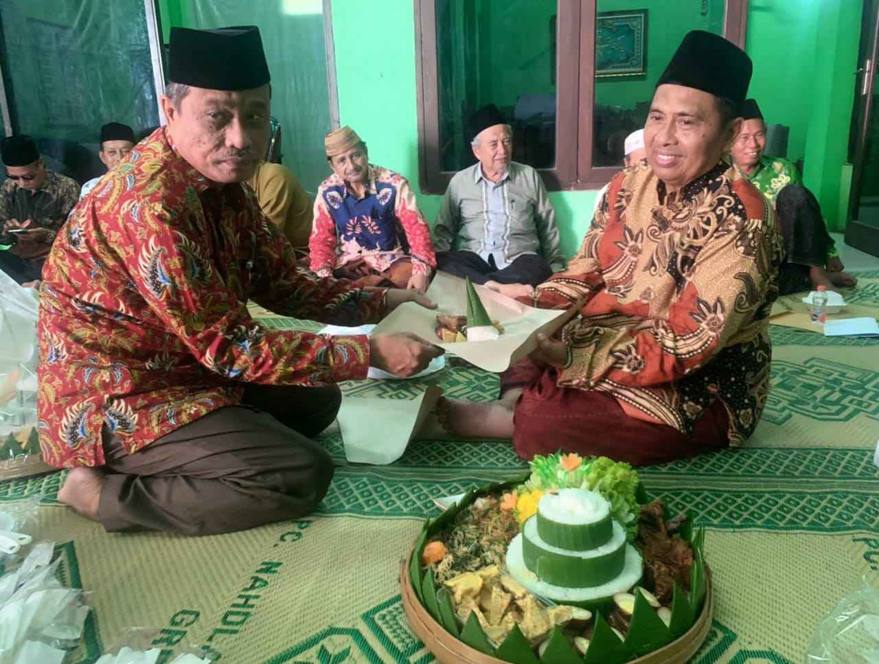 Ketua PCNU Gresik, KH Mulyadi (kanan) menerima pucuk tumpeng dalam tasyakuran setengah periode masa khidmat, Rabu (15/11/2023) di Kantor NU Cabang Gresik. Foto: Luthfi Ansori/NUGres