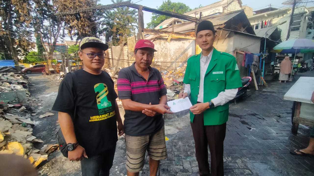 PEDULI. Pimpinan Anak Cabang Gerakan Pemuda Ansor Gresik memberikan bantuan kepada korban kebakaran Pasar Baru II Gresik, Senin (11/12/2023) kemarin. Foto: dok PAC GP Ansor Gresik/NUGres