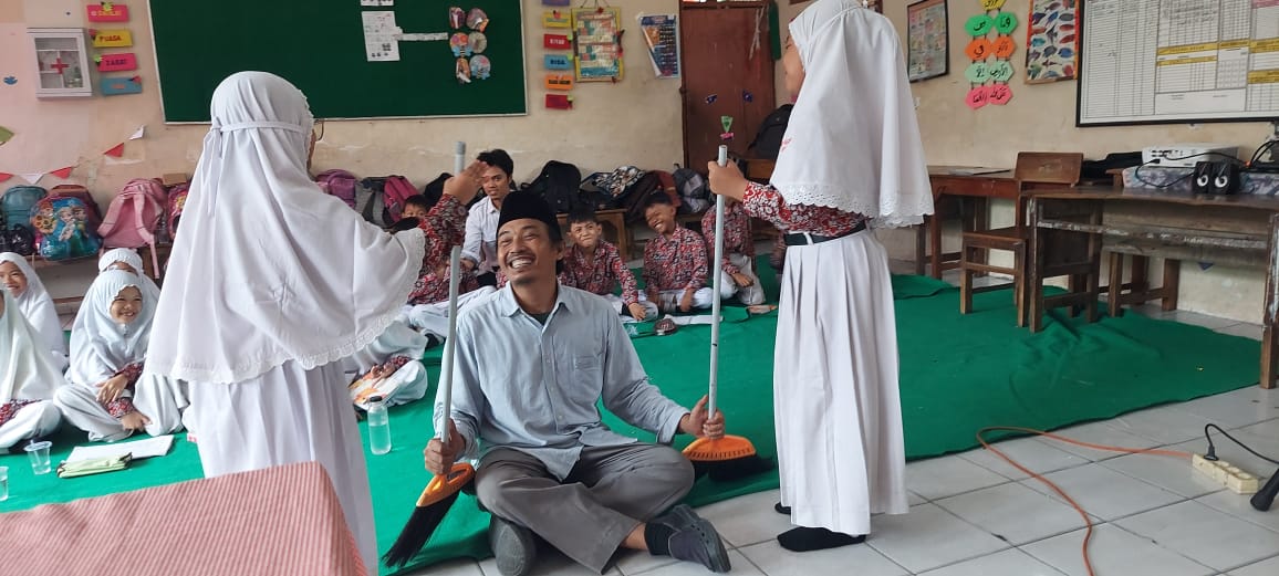 RIANG GEMBIRA. Pegiat Lesbumi NU kenalkan peserta didik UPT SDN 25 Gresik dengan kearifan lokal, tradisi hingga kebudayaan Gresik, Rabu (17/1/2024). Foto: Mustaghfirin/NUGres