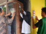 Satuan Tugas Gerakan Keluarga Maslahat Nahdlatul Ulama (GKMNU) Kecamatan Dukun Kabupaten Gresik saat melakukan penempelan stiker di rumah warga. Foto: dok Satgas GKMNU Kec. Dukun/NUGres