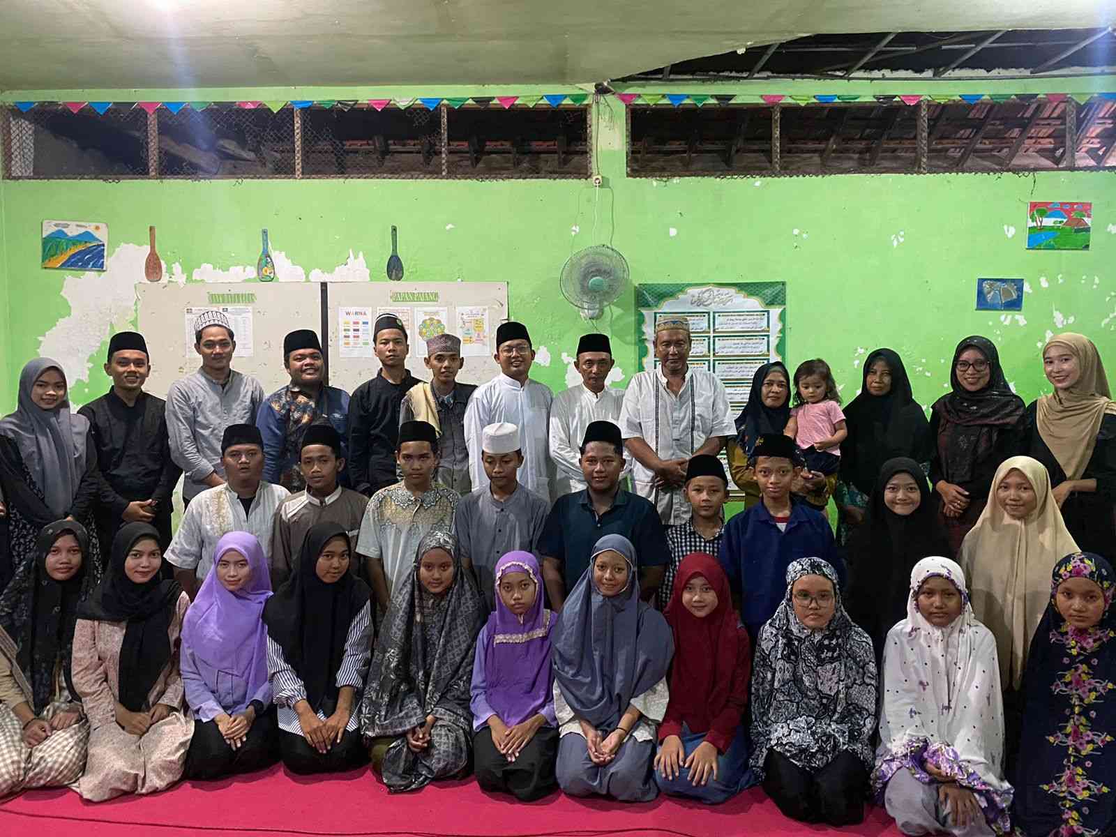 Peserta didik dan guru pendamping Pondok Ramadhan di MTs Manbaul Ulum Assa'adah di Desa Kramat, Duduksampeyan Gresik, foto bareng pegiat PAC IPNU IPPNU Duduksampeyan. Foto: dok PAC IPNU IPPNU Duduksampeyan/NUGres