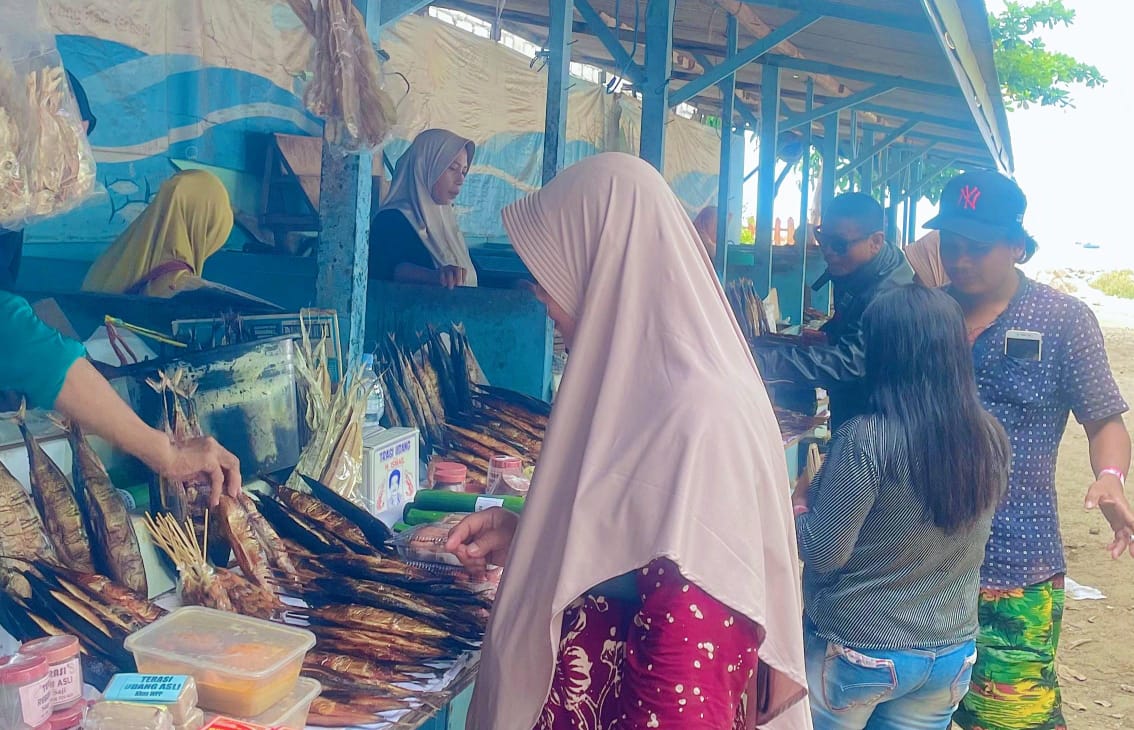 Pengunjung Wisata Pantai Pasir Putih Dalegan juga menyempatkan diri membeli oleh-oleh aneka olahan tangkapan laut nelayan. Foto: ira/NUGres