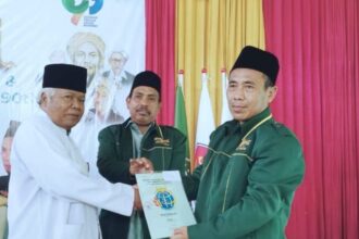 Penyerahan Sertipikat tanah wakaf oleh H Arif kepada Ketua MWCNU Sidayu H. Moh. Afrofil didampingi Rais Syuriyah MWCNU Sidayu, KH. Moh. Makruf (baju putih) di sela acara Halal Bihalal, Kamis (9/5/2024). Foto: Khanif Rosidin/NUGres