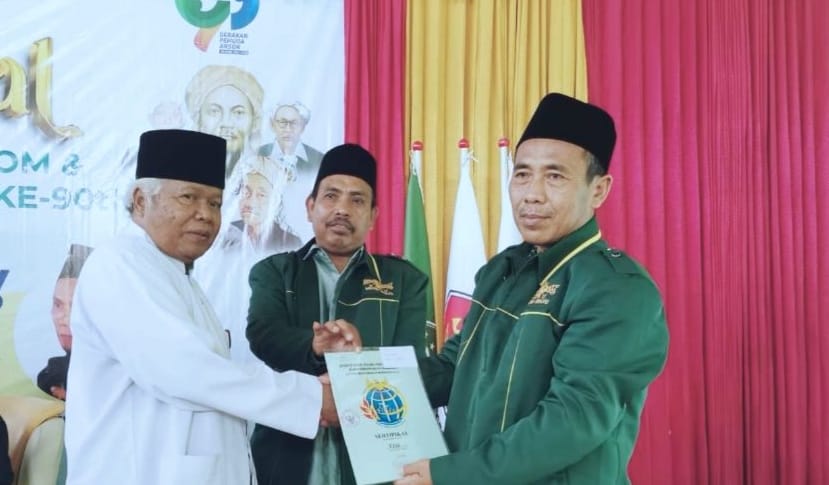 Penyerahan Sertipikat tanah wakaf oleh H Arif kepada Ketua MWCNU Sidayu H. Moh. Afrofil didampingi Rais Syuriyah MWCNU Sidayu, KH. Moh. Makruf (baju putih) di sela acara Halal Bihalal, Kamis (9/5/2024). Foto: Khanif Rosidin/NUGres