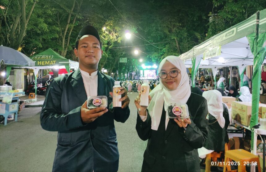 Pengurus Pimpinan Anak Cabang (PAC) IPNU IPPNU Gresik tampak bersemangat menyajikan produk di tengah gelaran puncak Hari Santri Nasional 2025 yang diselenggarakan oleh MWCNU Gresik, Sabtu (1/11/2025) malam. Foto: NUGres