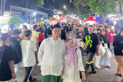 Camat Kebomas Tri Joko Efendi bersama istri mengabdikan momen di tengah semarak gelaran Malam Selawe Ramadan tahun lalu. Foto: dok Lutfhi/NUGres