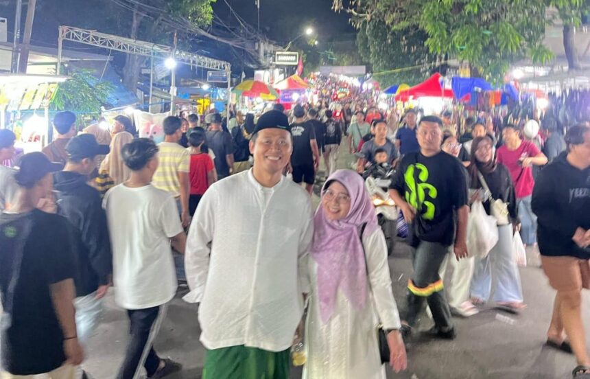 Camat Kebomas Tri Joko Efendi bersama istri mengabdikan momen di tengah semarak gelaran Malam Selawe Ramadan tahun lalu. Foto: dok Lutfhi/NUGres