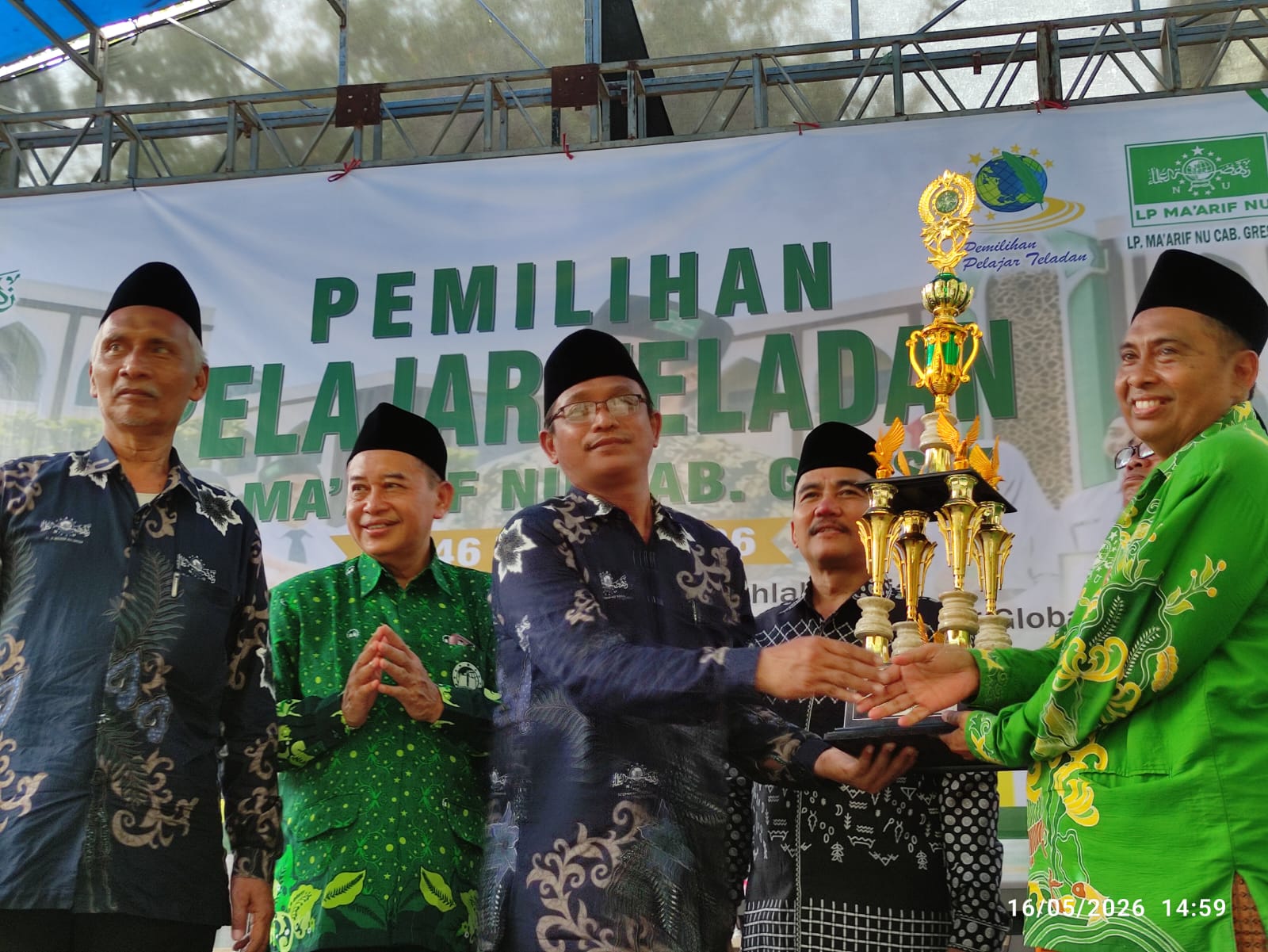 Tuan rumah acar Lomba Pelajar Teladan ke-46 Dr KH Muyadi saat menyerah trofi kepada peraih Juara Umum. Foto: NUGres